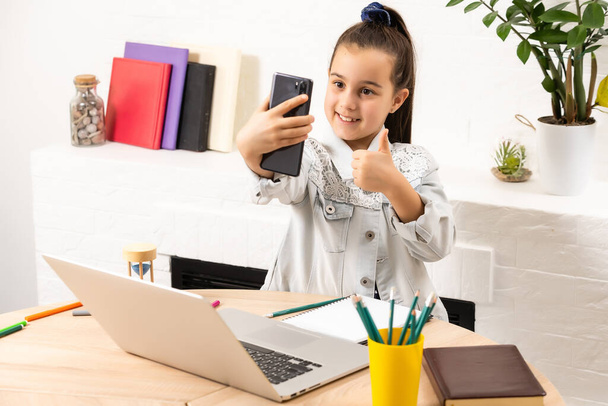 emberek, gyermekek és technológia koncepció - lány laptop számítógép és okostelefon csinál selfie vagy miután videohívás - Fotó, kép