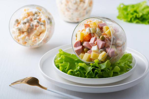 Traditionele Russische salade Olivier met groenten, ham en mayonaise. - Foto, afbeelding