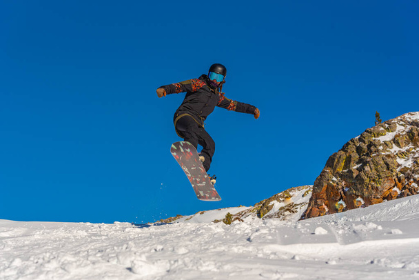 Mujer joven snowboarder en movimiento en snowboard en las montañas. - Foto, Imagen