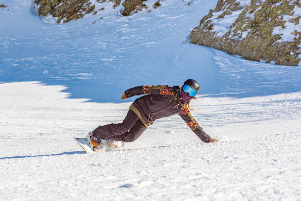Young woman snowboarder in motion on snowboard in mountains. - Photo, Image