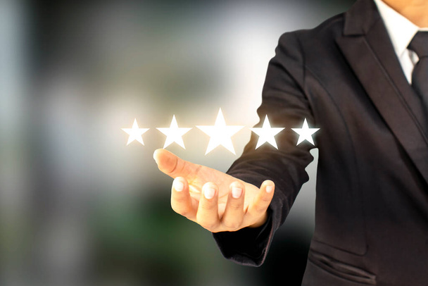 Los hombres de negocios están sosteniendo cinco estrellas, elevando su rango o elevando las calificaciones más altas, la mejor idea de evaluación y clasificación. - Foto, Imagen
