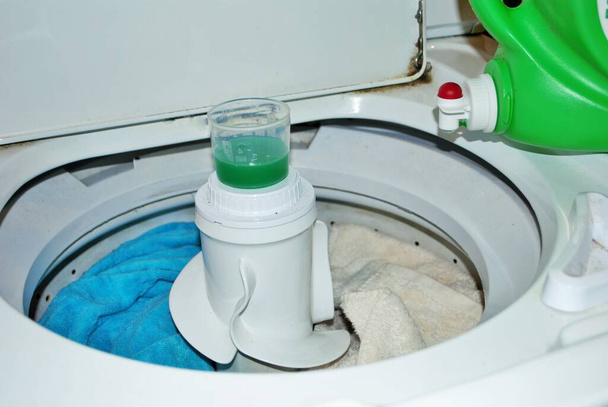 charge de serviettes sales dans une machine à laver avec détergent à lessive - Photo, image