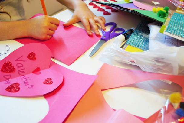 Παιδικά χέρια, ενώ κάνει σπιτικές κάρτες ημέρα του Αγίου Βαλεντίνου τέχνες και χειροτεχνίες - Φωτογραφία, εικόνα