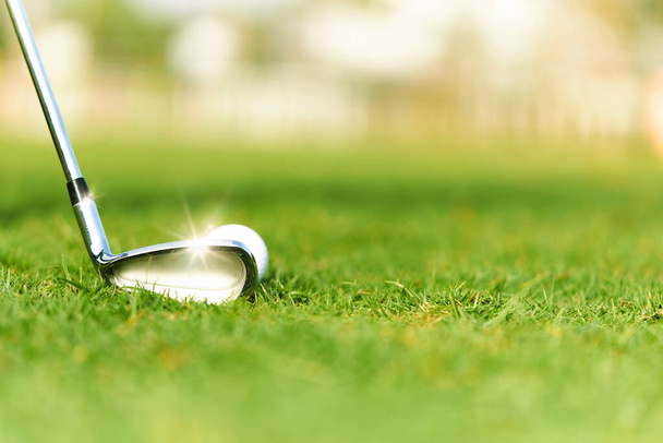 Golfschläger und Golfbälle auf einem grünen Rasen mit schönem Sonnenlicht. - Foto, Bild