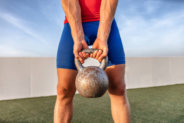 Kettlebell gewichtheffen fit man heffen crossfit gewicht in outdoor gym voor squat been workout - Foto, afbeelding