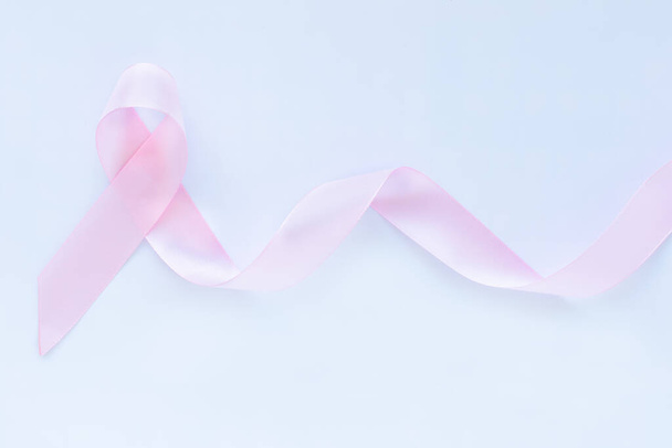 Pink ribbon curl on white isolated background with copy space. Breast cancer Awareness, male breast cancer disease, World Cancer Day. Healthcare or hospital and insurance concept. - Foto, immagini