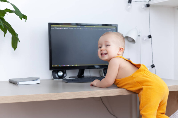 Caucásico divertido bebé niño explorando ordenador, monitor y teclado - Foto, imagen