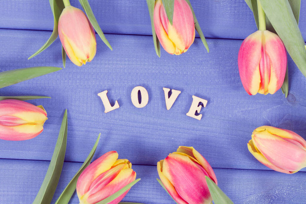 Word love and fresh tulips as surprise for Valentines Day, birthday or other occasions - 写真・画像