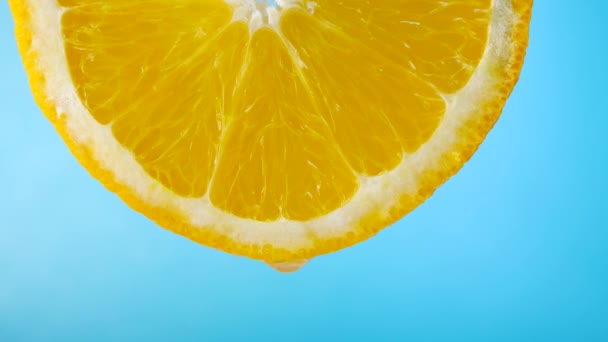 Fruchtfleisch-Orangen in Scheiben geschnitten auf blauem Hintergrund - Filmmaterial, Video