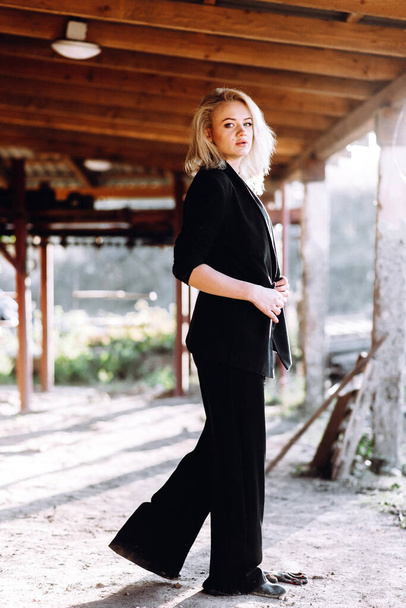 Retrato de una chica pelirroja vestida de negro retro en una vieja fábrica de ladrillos - Foto, imagen