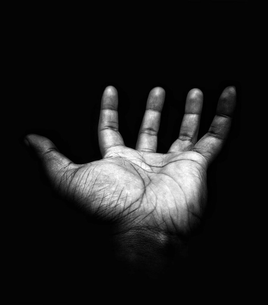 A man's open hand on a dark background. Use for creative work by adding features to the hand. - Фото, зображення