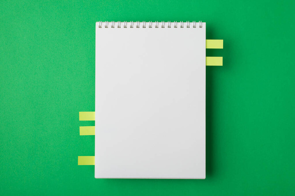 Fent a fejem fölött közeli mock up nézet fotó tiszta spirál notebook memo jegyzetfüzetek izolált élénk színű zöld asztal háttér - Fotó, kép