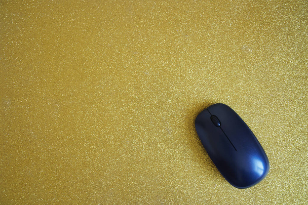 ワイヤレスコンピュータのマウスは光沢のある金のマウスパッドにあります。現代の技術と多様性。上からの眺め。碑文の自由空間. - 写真・画像