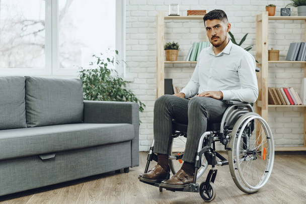 Portrait of disabled man in formal wear sitting in a wheelchair - Zdjęcie, obraz