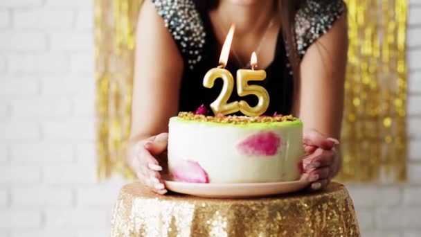 Joyeux jeune femme soufflant bougie d'anniversaire célébrant son 25e anniversaire à la maison. - Séquence, vidéo