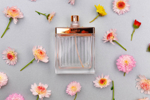 Bottle of fragrance surrounded by flower buds - Фото, зображення