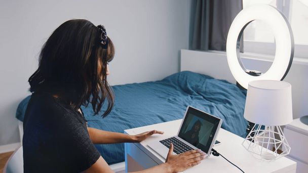 Mujer joven influencer grabación de vídeo en su dormitorio. Uso de la tecnología moderna e Internet durante el bloqueo - Foto, Imagen