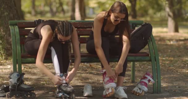 Two teenage girls rollerblading in the park - Footage, Video