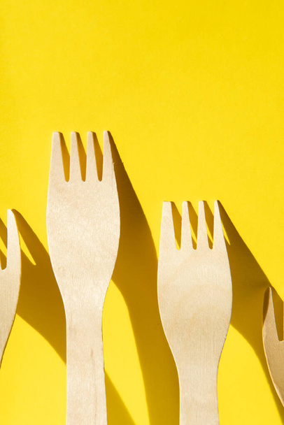 Wooden zero waste forks on a yellow background - Photo, Image