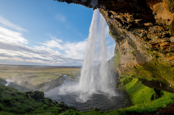 A beautiful view of the Seljalandsfoss waterfall in Iceland under a cloudy sky - 写真・画像