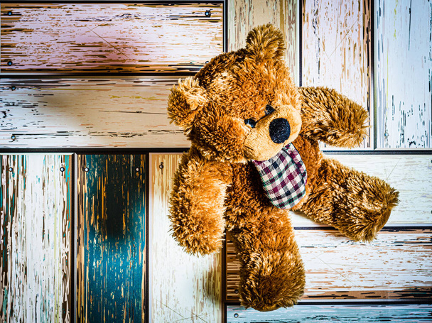A closeup shot of a teddy bear on wooden background - Фото, зображення