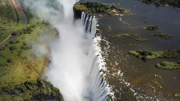 Το Victoria Falls στα σύνορα της Ζιμπάμπουε και της Ζάμπια στην Αφρική. Η Μεγάλη Victoria πέφτει Ένα από τα πιο όμορφα θαύματα του κόσμου.unesco Παγκόσμιας Κληρονομιάς. Εναέρια βολή από ψηλά. - Φωτογραφία, εικόνα