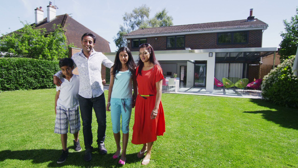 Portrait of happy asian family standing in the garden of their modern home - Felvétel, videó