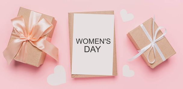 Gifts with note letter on isolated pink background, love and valentine concept with text Womens Day - Photo, image
