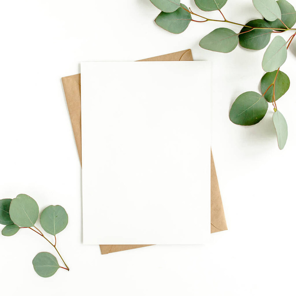Mockup invitation, blank greeting card and green leaves eucalyptus. Flat lay, top view. - Photo, Image
