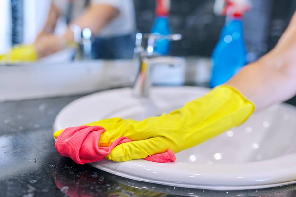 Close up of hands in gloves with detergent washing polishing washbasin - Foto, Imagem