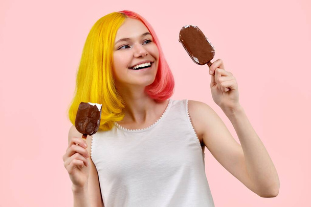 Beautiful smiling teenager girl with delicious chocolate ice cream on pink background - Photo, image