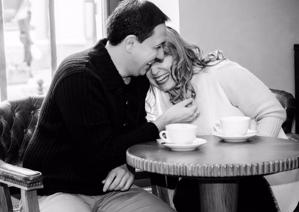 Zamilovaný pár středního věku sedí v kavárně, pije kávu, baví se a tráví spolu čas. Radostný milující dospělý pár odpočívající doma v zimě ráno - Fotografie, Obrázek