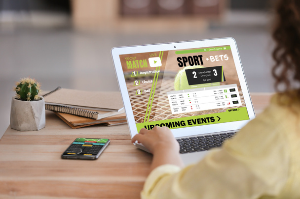 Young woman placing sports bet at home - Foto, afbeelding
