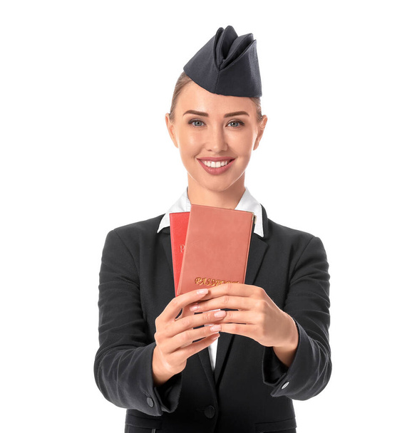 Mooie stewardess met paspoorten op witte achtergrond - Foto, afbeelding