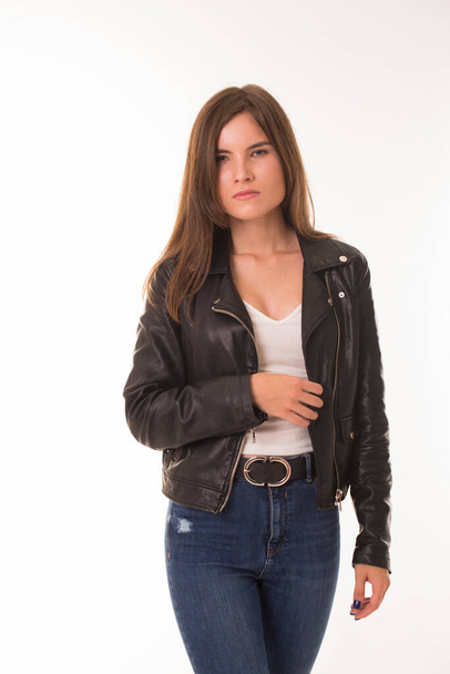 Brunette stands on a white in a leather jacket.  - Photo, image