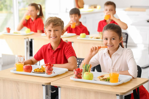 Pupils having healthy lunch in classroom - Photo, Image