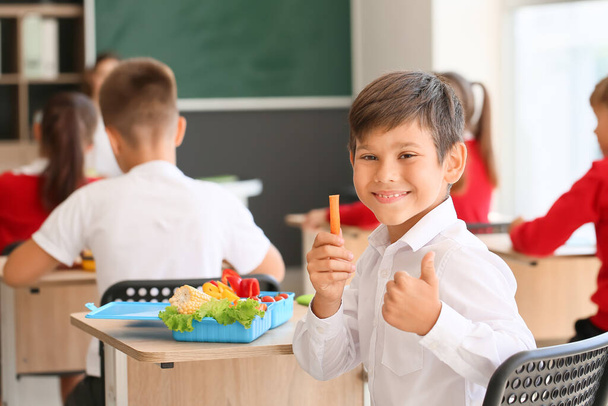 Schoolboy having healthy lunch in classroom - Photo, Image