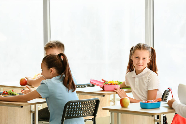 Pupils having healthy lunch in classroom - Φωτογραφία, εικόνα