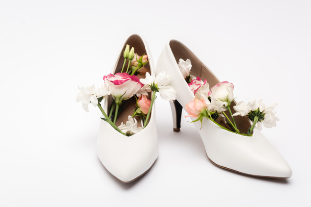 different flowers in female shoes on white background - Photo, Image