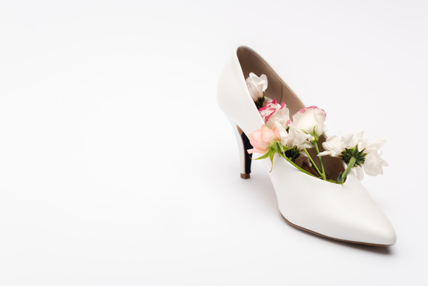 διαφορετικά λουλούδια σε θηλυκό παπούτσι σε λευκό χρώμα με χώρο αντίγραφο - Φωτογραφία, εικόνα
