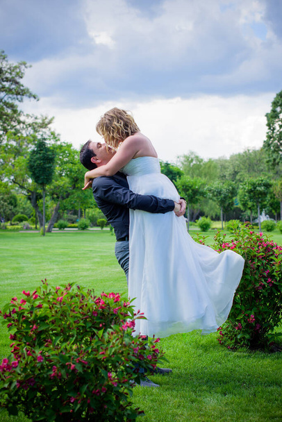 Blond bride and groom on wedding. Happy wedding couple. Beautiful bride, young woman in white dress groom kissing and having fun in outdoor on summer day. Just married, young family. - Fotografie, Obrázek