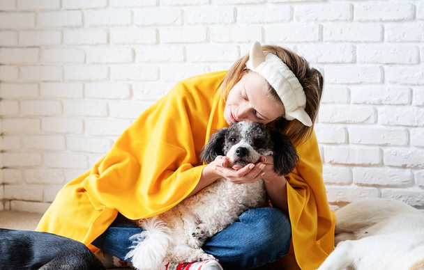 Pet care. Funny smiling young woman in yellow plaid sitting with her dogs reading a book - Photo, image