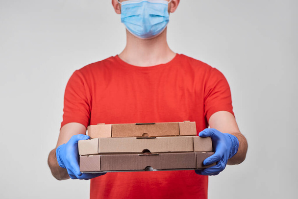 Delivery man brought three pizza boxes to a customer - 写真・画像