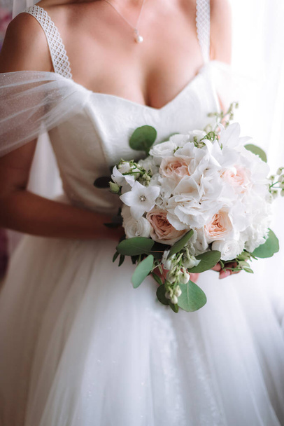 novia sosteniendo un ramo de flores en un estilo rústico, ramo de bodas. Enfoque suave - Foto, imagen