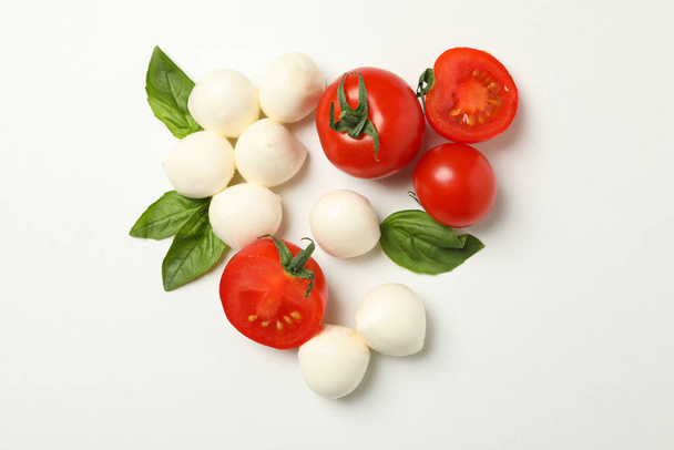 Mozzarella cheese, tomato and basil on white background - Foto, afbeelding