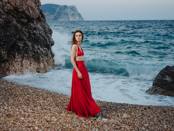 海のそばの島の赤いドレスを着た美しい女性 - 写真・画像