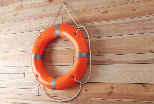 Orange lifebuoy and space for text on wooden background. Rescue equipment - Photo, image