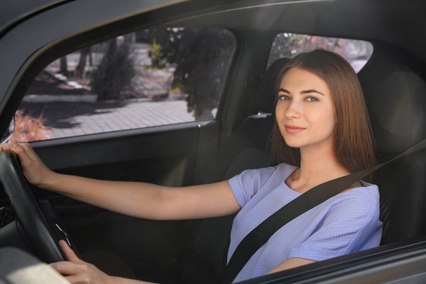 Young woman with fastened safety belt on driver's seat in car - Foto, afbeelding