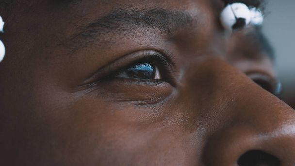 Auge eines schwarzen Mannes aus nächster Nähe. Tränen bei ängstlichem afrikanisch-amerikanischen Schwarzen - Foto, Bild
