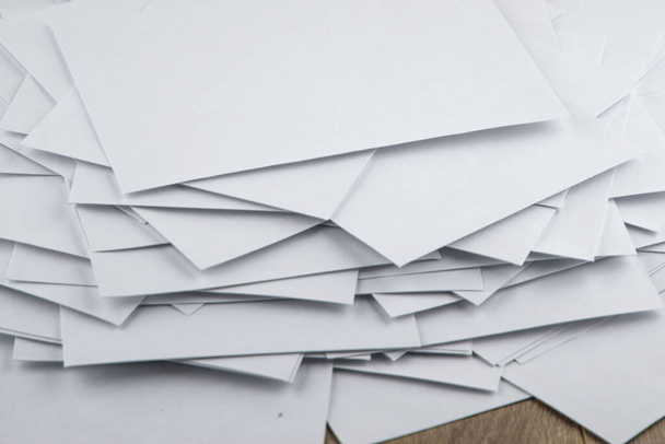 tension au travail : une énorme pile désordonnée d'enveloppes vides avec du courrier de travail sur le bureau du comptable, vue de côté d'en haut - Photo, image